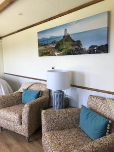 a living room with two chairs and a lamp at Ty Beti in Holyhead +10 photos