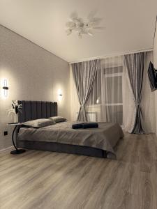 a bedroom with a bed and a ceiling fan at Уютная новая квартира в ЖК Береке 2 рядом с Kostanay Plaza in Kostanay