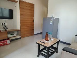 a living room with a coffee table and a refrigerator at The Cave Lakeview Suites 1BHK in Bangalore +8 photos
