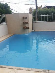 a swimming pool with blue water in a backyard at Solar Hotel in São Fidélis