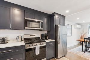 cocina con armarios negros y nevera de acero inoxidable en Village Green 9F, en Stowe