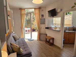 a living room with a couch and a kitchen at nos appartements ciel et mer a tenerife in Puerto de la Cruz