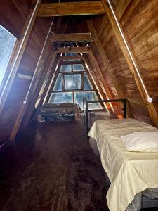 an attic room with a bed and a window at Chalé da Serra in Araruna