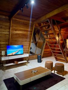 a living room with a tv and a table and chairs at Chalé da Serra in Araruna +24 photos