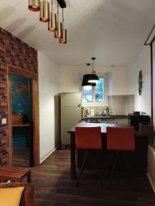 a kitchen with a table and two red chairs at La Petite Fabrique in Villedieu-sur-Indre