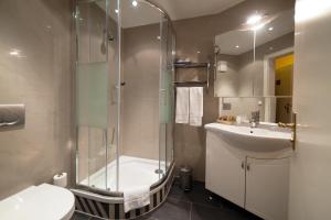 a bathroom with a shower and a sink and a toilet at Atlas Grand Hotel in Garmisch-Partenkirchen