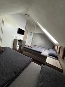 a bedroom with two beds and a sloped ceiling at Hotel Linda in Gladbeck +7 photos