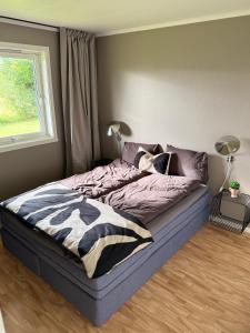 una camera da letto con un letto grande con una finestra di Stor leilighet nær flyplass, buss og natur a Tromsø