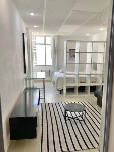 een woonkamer met een bed en een tafel en een kamer met een bed bij Centro - Ao lado da Lapa in Rio de Janeiro