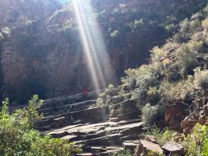 a person standing on stairs in a canyon with the sun shining on them at La casa de Beatriz Paz, Confort y Tranquilidad in San Rafael