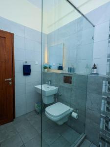 une salle de bain avec toilettes et lavabo dans l'établissement Luxury Beachfront apartment at Baobab Waves, à Mombasa