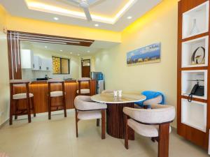 une pièce avec une table et des chaises et une cuisine dans l'établissement Luxury Beachfront apartment at Baobab Waves, à Mombasa