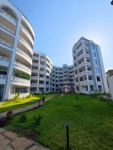 deux grands bâtiments avec une pelouse devant eux dans l'établissement Luxury Beachfront apartment at Baobab Waves, à Mombasa