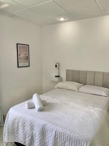 een slaapkamer met een bed met een witte deken bij Centro - Ao lado da Lapa in Rio de Janeiro