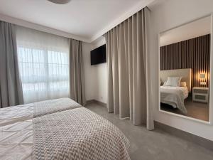 Un dormitorio con una cama y un espejo grande. en Izaro Apartamento Atico de Lujo cerca de Playa Dorada, en Playa Blanca