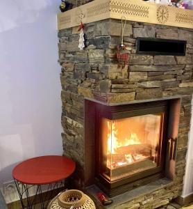 a stone fireplace with a red stool in front of it at Domek Tatry - Stacja Wierchowa 972 m in Brzegi