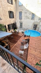 a wooden deck with a swimming pool and chairs at Dreamhome B&B Limoux in Limoux