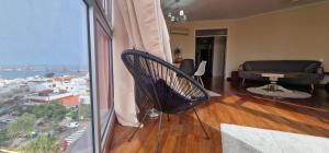 a living room with a chair and a view of a city at Vista triangular in Las Palmas de Gran Canaria