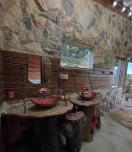 a stone bathroom with two red sinks in it at Pousada Toca da Raposa in Cavalcante +59 photos