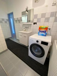 a washing machine in a bathroom with a sink at Apartment Q im Zentrum von Königsbronn in Königsbronn