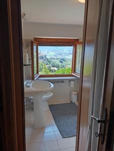 a bathroom with a sink and a window at Casa Il Tramonto Sunset house in Gualdo Cattaneo