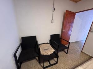 two black chairs and a table in a room at Dulces sueños in Roque Sáenz Peña