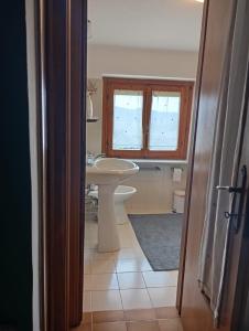 a bathroom with a white sink and a toilet at Casa Il Tramonto Sunset house in Gualdo Cattaneo +21 photos