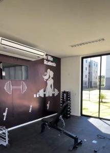 een fitnessruimte met een muur met een bord erop bij Apartamento moderno e aconchegante in Juazeiro do Norte