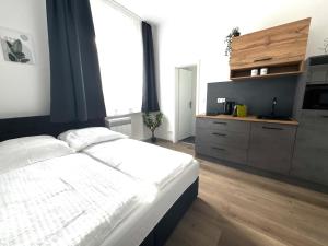 ビーレフェルトにあるModern studio for 2 - Central I Parking I WiFiの白いベッドと大きな窓のある寝室 +2枚の写真