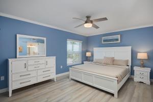 une chambre avec un lit et un ventilateur de plafond dans l'établissement Villa Sanibel 2A - Exclusive Villa Sanibel Retreat Steps to Beach, à Ybel