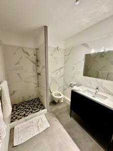 un bagno bianco con lavandino e WC di Large central 2 bedroom, ideal for family or pro stay a Marigot