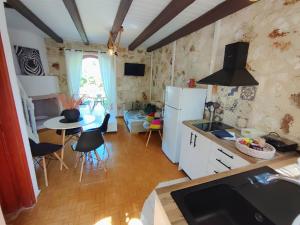 a kitchen with white appliances and a table with chairs at Spasmata Village Special Maizonette only adults in Minia