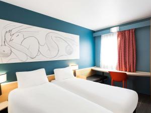 a hotel room with two beds and a desk at ibis Besançon Centre la City in Besançon +147 photos