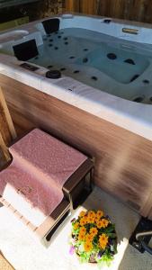 パラッドにあるEperkert Vendégházの浴槽とトレイ、そして床に花が飾られている