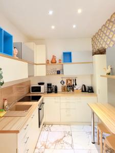 Una cocina con gabinetes blancos y una mesa. en Charme Boutique Old Town, en Brasov