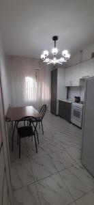 a kitchen with a table and chairs in a room at Квартира in Tridtsatʼ Let Kazakhstana
