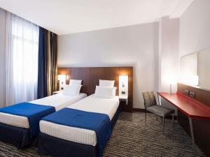 a hotel room with two beds and a desk at Mercure Roma Piazza Bologna in Rome +115 photos
