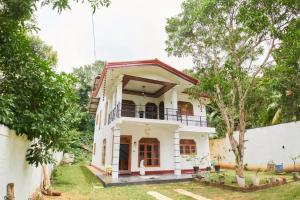a white house with trees in front of it at Sea Breeze Rest in Talalla South