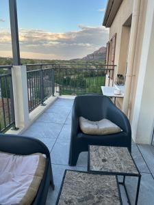 a balcony with a chair and a coffee table at Appartement proche mer in Le Muy