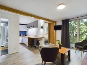 Una cocina y una sala de estar con mesa y sillas. en Apartamenty Dabrowka Budget - w lesie, prywatny parking, sauna, park, en Jelenia Góra