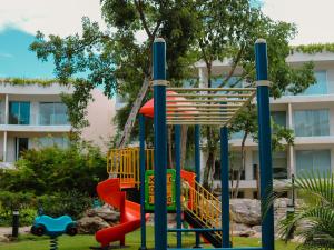 a playground in front of a building at Stylish Playacar Condo with Balcony & Pool in Playa del Carmen
