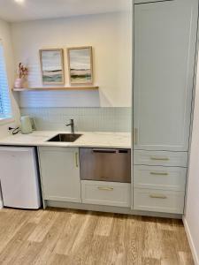 a kitchen with white cabinets and a sink at The Quarters in Turangi +57 photos