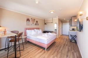 a bedroom with a bed and a table and a kitchen at WEIDE SUITES Stubaital - Adults Only in Schönberg im Stubaital