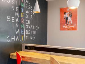 a room with a black wall with a bench and a poster at Ibis Bilbao Barakaldo in Barakaldo +75 photos