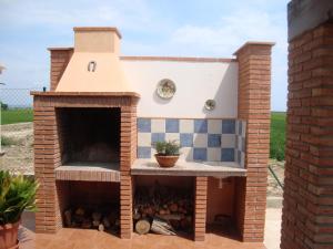 a brick pizza oven with a fireplace in a yard at Caseta Les Creus in Riumar