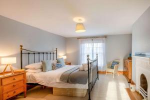 a bedroom with a large bed and a fireplace at China Cottage in Weybourne