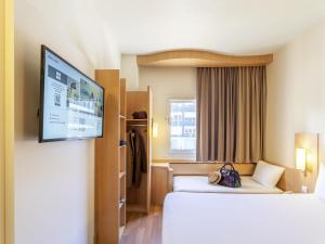 Una habitación de hotel con dos camas y un televisor de pantalla plana. en Ibis Madrid Calle Alcalá, en Madrid
