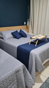 dwa łóżka ze stołem na górze w obiekcie Flat Apart hotel Village - ao lado do Aldeia das Aguas w mieście Barra do Piraí +18 zdjęć