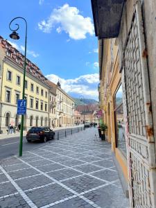 una calle adoquinada en una ciudad con un coche en ella en Charme Boutique Old Town, en Brasov