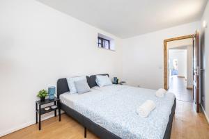 a bedroom with a bed with a blue comforter at Casa da Legua -Panoramic Ocean View w Terrace in Pataias +40 photos